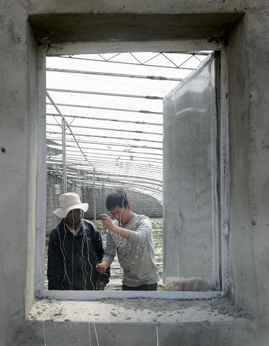 Beschreibung: Zhang Xiaobo(rechts) vermittelt den Dorfbewohnern