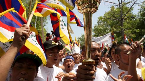 Beschreibung: Tibeter mit Fackel und Flagge. Quelle: dpa