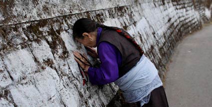 Beschreibung: Eine Exil-Tibeterin betet vor der Residenz des Dalai Lamai in Indien (Quelle: AP)